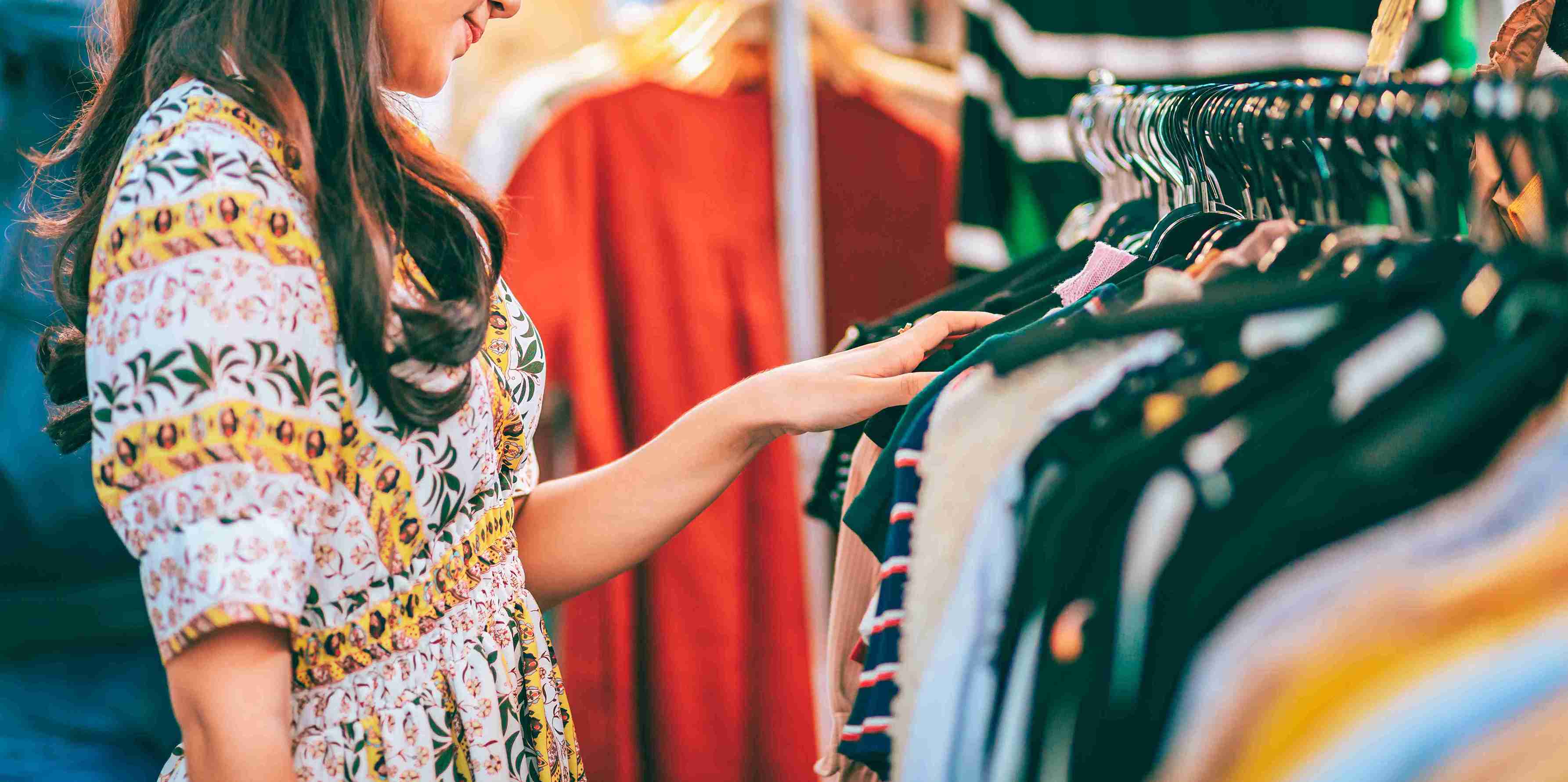 Two people looking through a clothing rack in a local shopping boutique