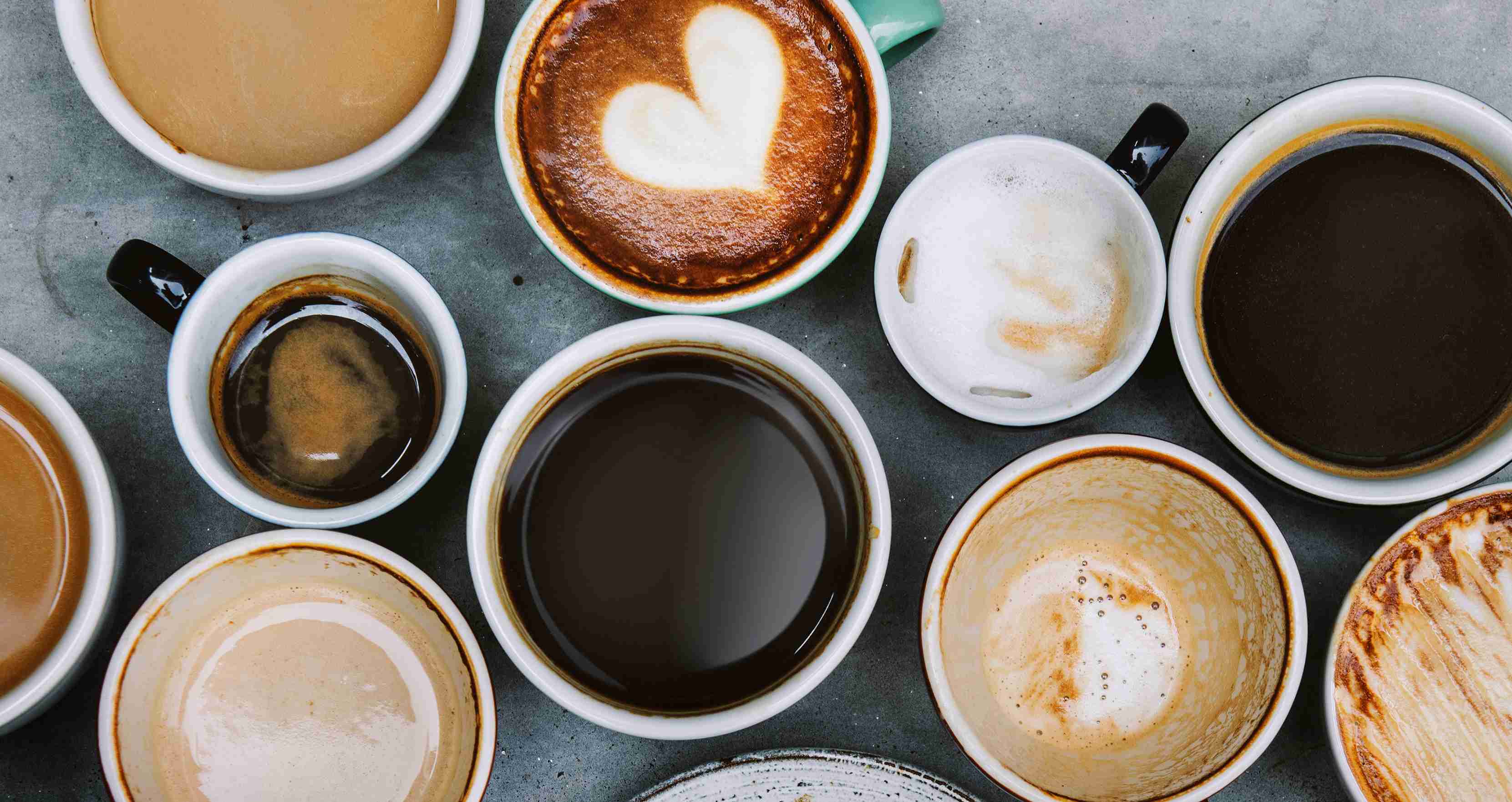 A cup of coffee in a white mug sitting on a wooden table